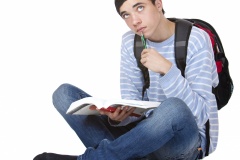 Junger männlicher Student mit Buch lernt und denkt nach